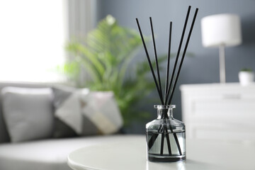 Aromatic reed air freshener on white table in room. Space for text - obrazy, fototapety, plakaty