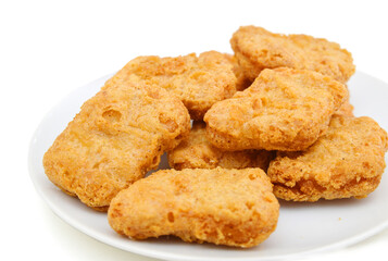 Fried chicken nuggets isolated in white plate on white