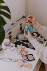 Everyday beauty routine. Make up artist. Dressing vanity. Women's hands. Pastel colors. In front of the mirror. Palettes, brushes, mascara, lipstick. White bright bedroom. Early morning light.