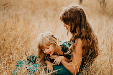 Mom hugs and laughs with her daughter in nature
