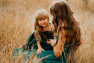 Mom hugs and laughs with her daughter in nature