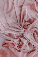 Velvet pastel blush pearl pink fabric. Soft cocktail dress. Pastel color. Close up. Textile texture. Background wallpaper. Silk pattern.