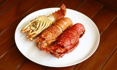 Boiled lobsters on white plate. Wood background.
