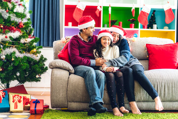 Portrait of happy asian family father and mother with daughter in santa hats having fun look at camera and enjoying spending time together in christmas time at home