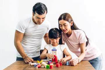 Portrait of enjoy happy love asian family father and mother with little asian girl smiling playing with toy build wooden blocks board game in moments good time at home