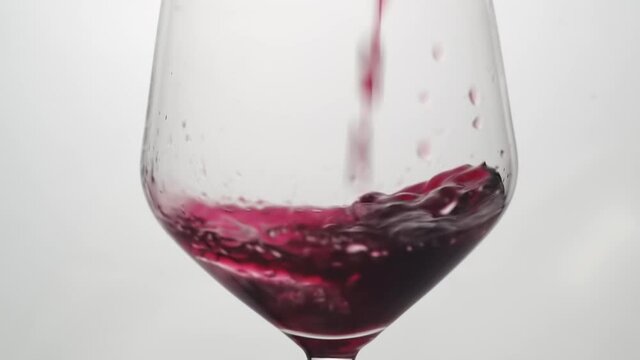 Sirviendo Vino tinto en una copa de cristal en c&aacute;mara lenta.