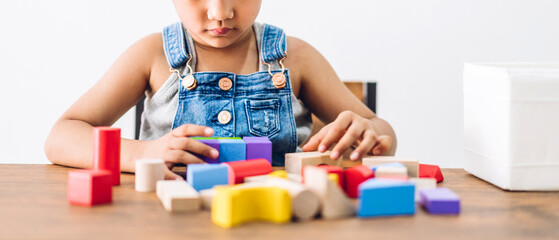 Portrait of enjoy happy asian little asian girl smiling playing with toy build wooden blocks board game at home