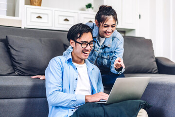 Young asian couple relaxing using laptop computer working and video conference meeting online chat.Creative business couple planning and brainstorm at home