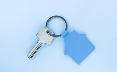 key chain with house symbol and keys on green background,Real estate concept