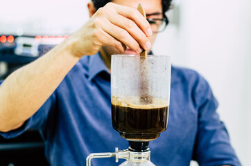Professional coffee maker - Barista using coffee siphon brewing hot espresso at coffee shop