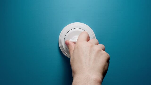 Human Switches On A Toggle Switch On The Blue Wall