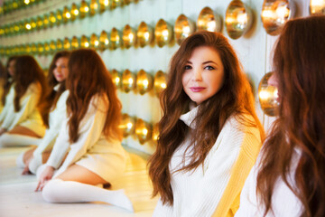 Beautiful young woman with many reflections in the mirror.