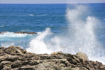 Fototapeta na wymiar 岩場に打ち付けて砕ける波