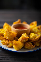 Deep fired Chinese Thai style wonton with minced pork and sweet and sour sauce in ceramic dish.