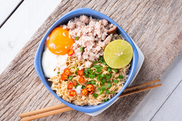 Instant noodles with minced pork and egg in bowl.