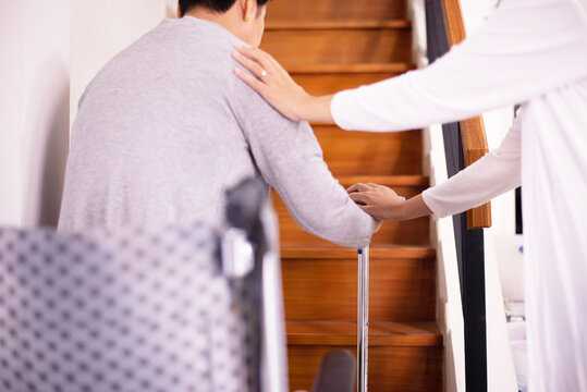 Elderly woman hands holding sticks while walking up stair at home,Caregiving take care and support,S