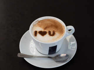 A cup of hot coffee cappuccino, latte decorated with  I love you message heart 