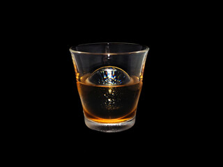 Tokyo,Japan-January 8, 2021: Round Ice Cube in a glass on black background
