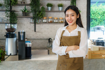 Asian man Barista or owner small business in apron looking at camera and arm crossed at the modern coffee shop