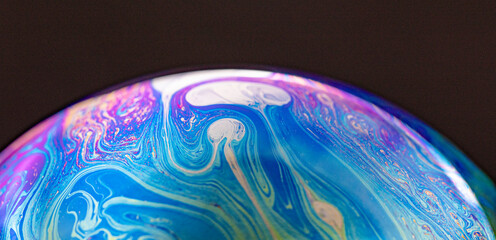 Closed up colourful wave and patterns with  rainbow effects in bubbles isolated on black background.