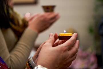 People holding small candle holders in the blessing