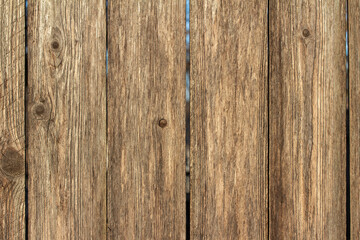 Naklejka premium Full frame texture background of a wooden fence with natural wood grain planks, in bright sunlight