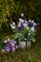 Purple Flowers in a Cement Pot with a Cross in Front
