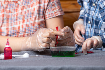 Chemical experiments with a child. Mom and her son make polymer worms at home