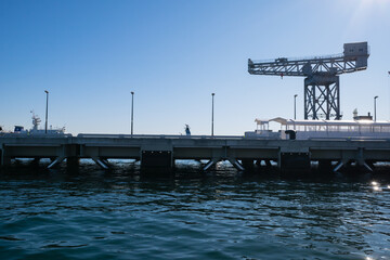 Obraz premium 日本の横浜にある客船ターミナル。クルーズ船が停泊する桟橋とシンボルのハンマーヘッドクレーン。