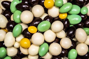 Colorful sweets: nuts in different types of chocolate, edible pattern