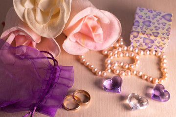 Wedding preparations. Two wedding rings, pearl beads, flowers and hearts. The photo