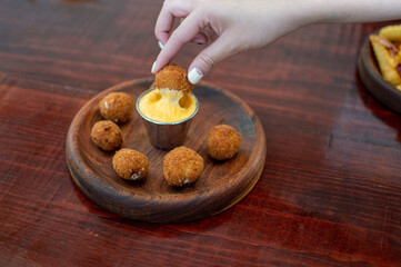 beautiful woman holding crispy fast food dipping in cheese sauce