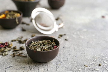 Fototapeta na wymiar Bowl with green tea leaves on color background