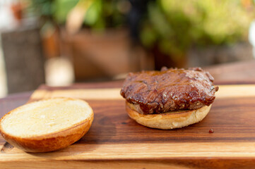 preparation of burger on wooden board and sauce