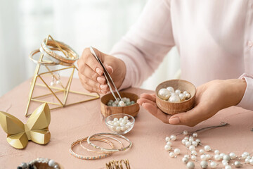 Female designer making jewelry at workplace