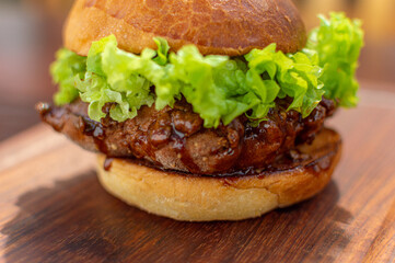 perfect burger with artisan bread on wooden board with double meat and sauce, fast food