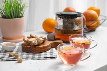 Cups of healthy tea with lemon and ginger on table