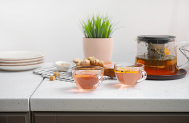 Cups of healthy tea with lemon and ginger on table