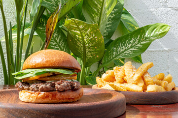 delicious hamburger with delicious meat with vegetables with artisan bread on wooden board and french fries fast food