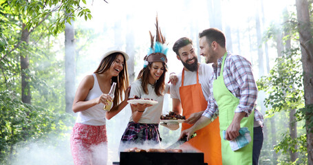 Friends making barbecue and having lunch in the nature