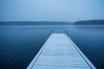 Stockholm, Sweden A lonely jetty in the snow at the Flatenbadet park and lake, a recreational area.