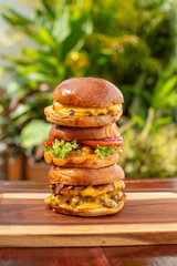 three delicious hamburgers with extra meat and cheese on wooden boards fast food