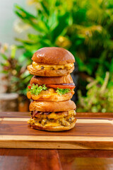 three delicious hamburgers with extra meat and cheese on wooden boards fast food