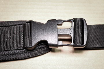 Black plastic buckle fastex for backpacks. Accessories for backpacks, fastener close-up.