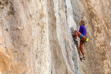 girl climbs a rock-climbing route. outdoor sports.