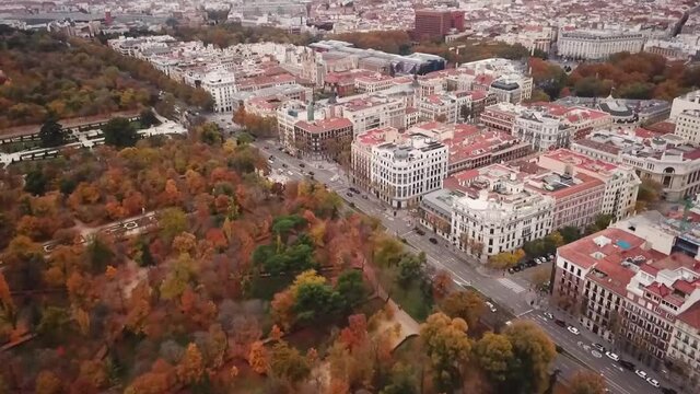 Spain Madrid Parque de El Retiro Calle de Alfonso XII  aerial drone shot look view from above autumn park fly towards the street pan up
