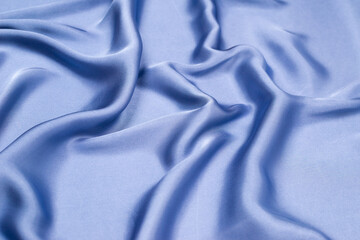 Blue silk or satin luxury fabric texture. Top view.