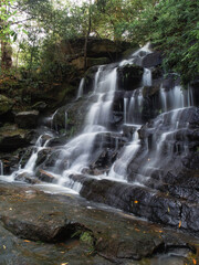 Fototapeta na wymiar Side view of a tall rocky waterfall.