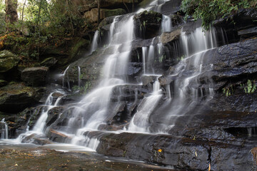 Fototapeta na wymiar Side view of a tall rocky waterfall.