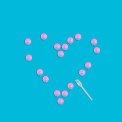 Creative Valentines day concept with heart symbol made of pink balloons and fork on pastel blue background. Flat lay design 